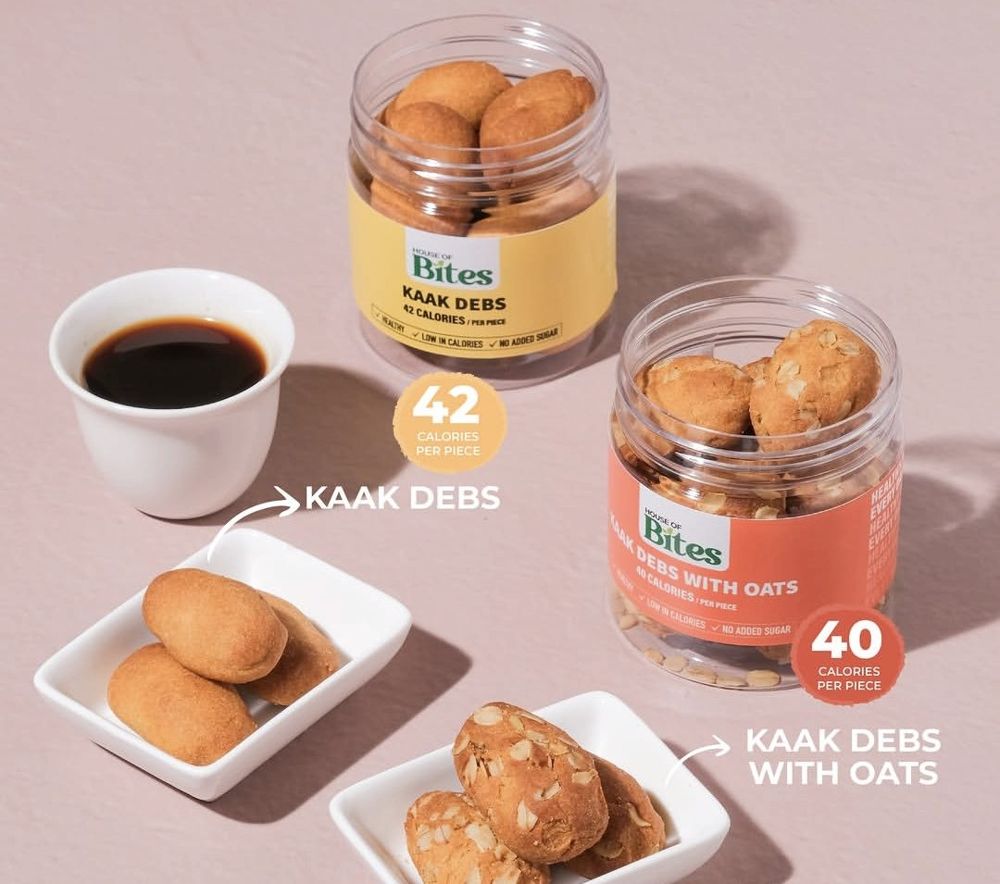 Two House of Bites jars, Kaak Debs and Kaak Debs with Oats, with a cup of black coffee and the biscuits on white plates.